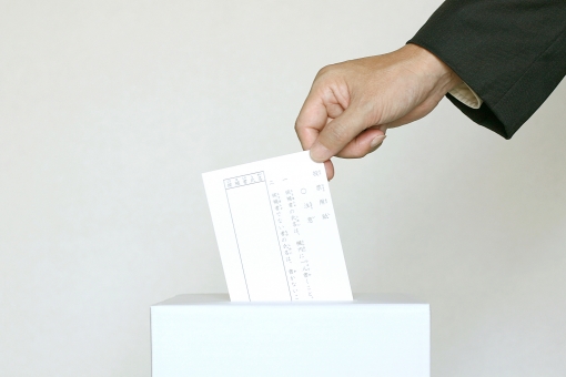 投票する人の手と投票箱